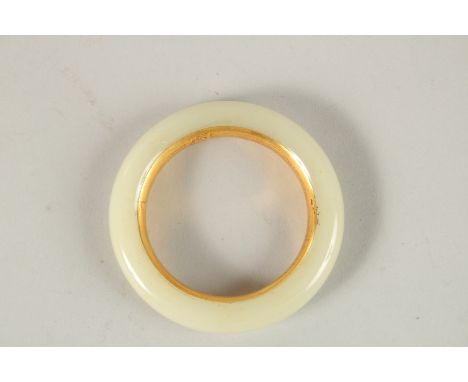 A CHINESE WHITE JADE AND GILT BANGLE. 8cms diameter.