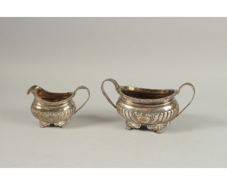 A GEORGE III TWO HANDLED SUGAR BASIN AND MILK JUG on claw feet. London 1819, weight: 16ozs.