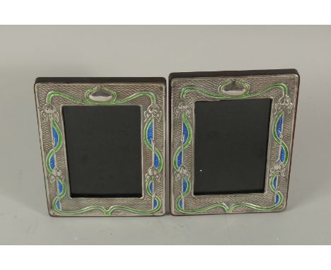 A PAIR OF SILVER AND ENAMEL ART DECO PHOTOGRAPH FRAMES. 21cms x 14cms.