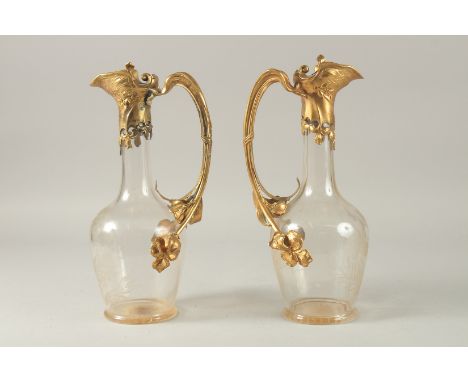 A GOOD PAIR OF ART DECO ENGRAVED GLASS AND GILT METAL CLARET JUGS, engraved with flowers. 31cms high.