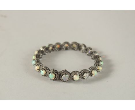 A GOOD OPAL AND DIAMOND BANGLE set with twenty four opals.