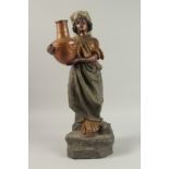 A GOLD SHIELD POTTERY ARAB WOMAN carrying a pitcher. 60cm high.