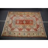A TURKISH MILAS TABAN CARPET red ground with stylised decoration. 12ft 6ins x 9ft 10ins.