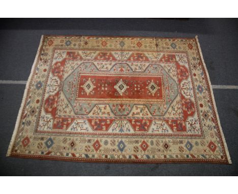 A TURKISH MILAS TABAN CARPET red ground with stylised decoration. 12ft 6ins  x 9ft 10ins.