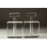 A PAIR OF CUT GLASS CIRCULAR PERFUME BOTTLES AND STOPPERS. 13cms high.