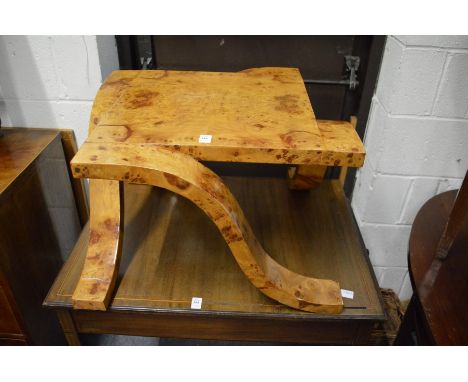 AN UNUSUAL ART DECO STYLE BURR WOOD COFFEE TABLE with curving legs.