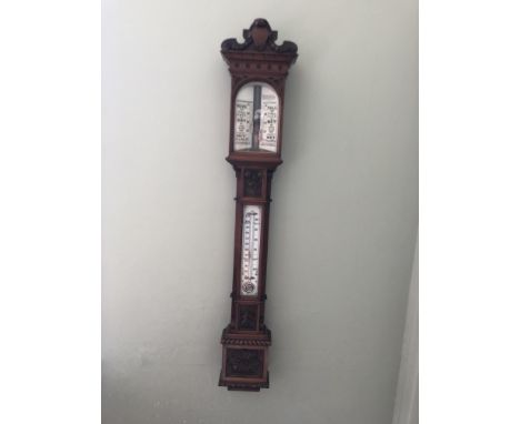 A large victorian carved architectural mercurial barometer,with corinthian column sides with a broken arched pediment top,wit