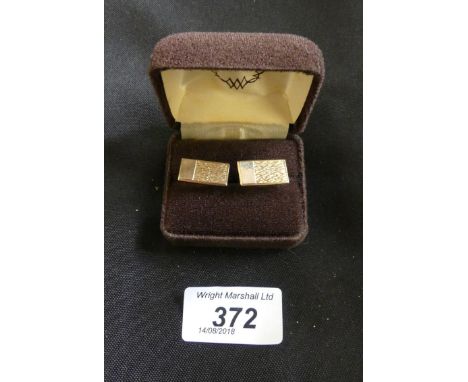A pair of 9ct gold cufflinks. Each designed as a rectangular shape textured panel with T-bar reverse. Hallmarks for Birmingha
