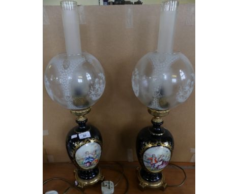 A pair of modern oil lamp style table lamps with ceramic bases, decorated with classical scenes, fitted with frosted glass sh