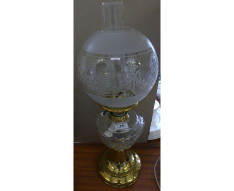 An early 20th Century oil lamp, with cut clear font over a brass base, fitted with a frosted glass shade
