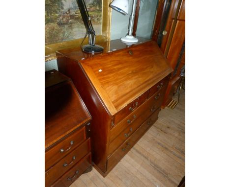 A Georgian mahogany bureau, the plain fall front drops to enclose fitted interior with central inlaid panel above two short a