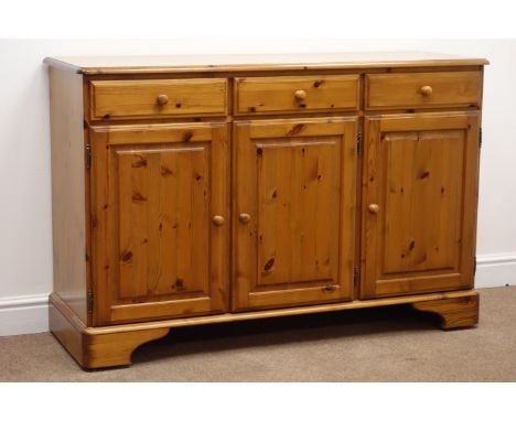 Ducal pine dresser, two glazed doors with central shelves, above three drawers and three cupboards, on shaped bracket support