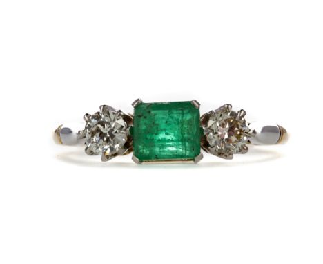 EMERALD AND DIAMOND RING, set with an octagonal step cut emerald of approximately 0.66 carats, flanked by two round brilliant