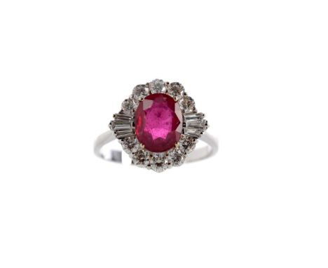 GLASS FILLED RUBY AND DIAMOND RING, set with a glass filled ruby within a halo of round brilliant and tapered baguette cut di