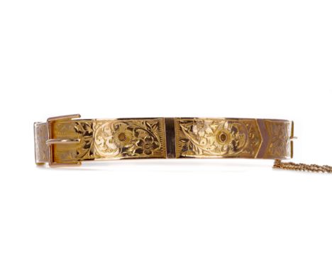 GOLD BUCKLE BANGLE, with engraved foliate decoration, in nine carat gold, with safety chain, 13.5g