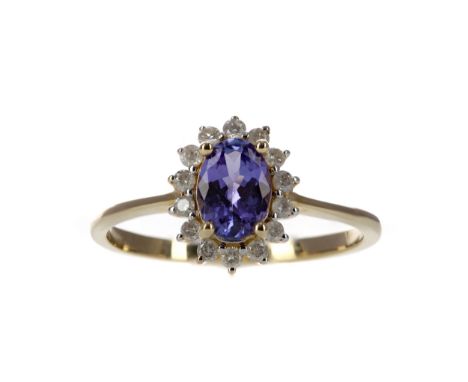 TANZANITE AND DIAMOND RING, set with an oval taznzanite within a halo of round brilliant cut diamonds totalling approximately