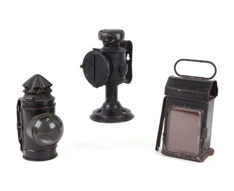 Three railway lamps, one with blackout slit, 20cms high; another with bulls eye lens and rear lamp (3).