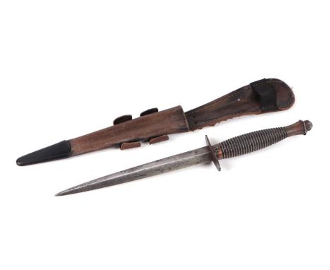 A Fairbairn Sykes style fighting knife with leather scabbard, 30cms long.