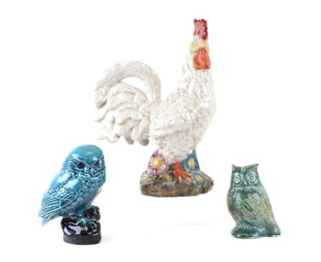 A large pottery cockerel, 37cms high; together with a Poole pottery owl, 17cms high and another similar, 13cms high (3).