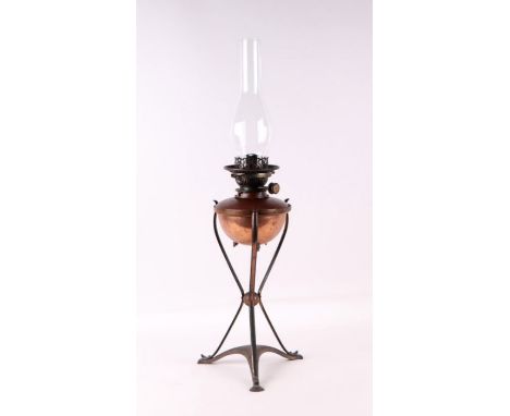 A Benson &amp; Co Arts &amp; Crafts brass and copper oil lamp with copper reservoir within a brass cage, on splayed curved le
