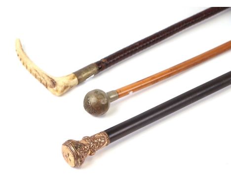 A late 19th century ebonised walking cane with gilt metal handle, 91cms long; together with a military bull top swagger stick