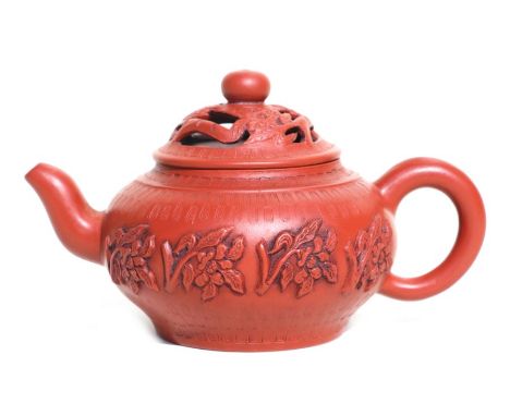 A Chinese Yixing pottery teapot decorated with flowers, impressed seal mark to the underside, 8cms high.