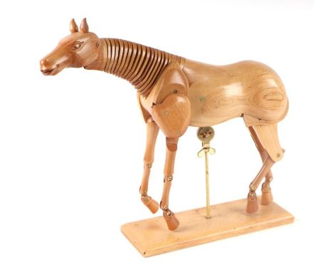 An artist's treen articulated horse model, approx 35cms long, mounted on a plinth.