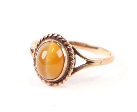 A 9ct gold dress ring set with an oval tiger's eye cabochon, approx UK size 'O', 2.3g.