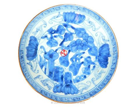 A Chinese blue and white porcelain dish, hand painted, stamped with a seal (chip and hairline crack), 23cm diameter.