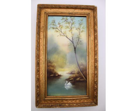 A framed late 19th century painted porcelain tile, depicting a swan gliding across a woodland lake, period gilt frame, 38cm t