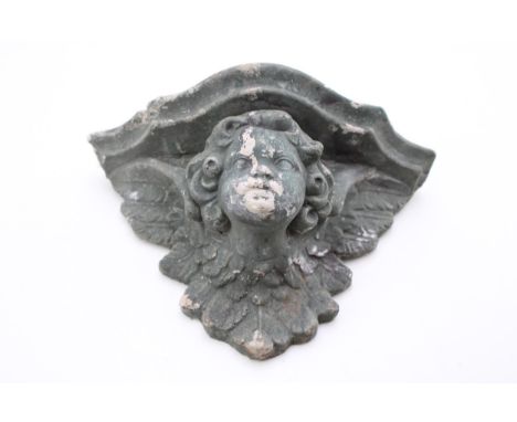 A reconstituted stone shelf in the form of a cherub. Height 16cm, width 15.5cm.