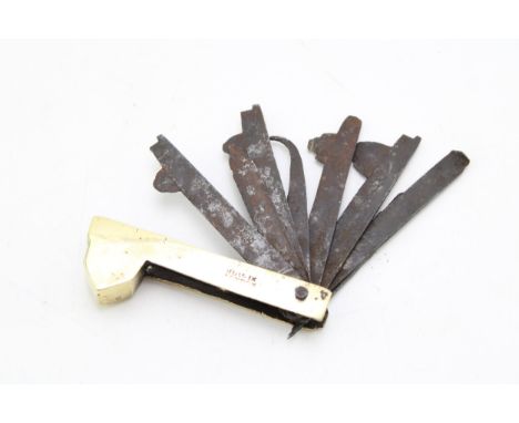 Antique brass cased fleam with eight blades / tools, indistinct impressed marks, possibly How In London, 9.5cm wide.