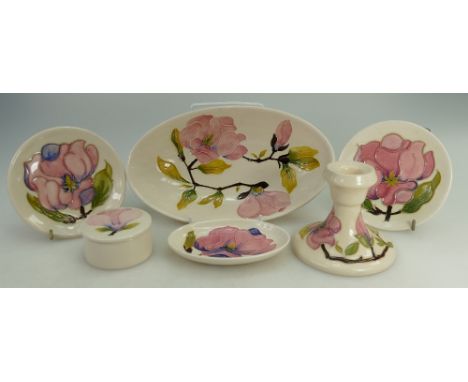 A collection of Moorcroft pottery in the Magnolia design comprising dishes, candlestick, large oval dish etc (6)