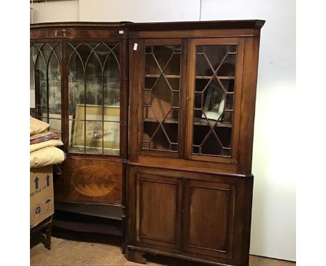 A 19thc two part corner cabinet, the cornice above a pair of glazed astragal panelled doors, with shelved interior above a pa