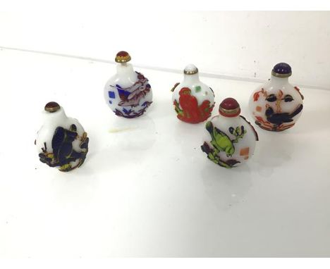 A group of Chinese snuff bottles, four decorated with birds and branches, one with monkeys, complete with top and spoons (one