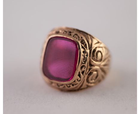 9ct GOLD SYNTHETIC RUBY RING. A rectangular synthetic ruby plaque, in a rubbed over setting, to a scroll shank, rings size K,