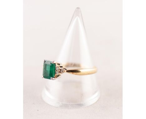 A GOLD (no carat mark) RING, set with an emerald between shoulders set with six tiny diamonds, 4.1gms