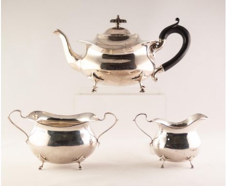 GEORGE V COMPOSITE THREE PIECE SILVER TEA SET OF OVAL FORM and raised on scroll feet, tea pot with ebony "S" scroll handle an