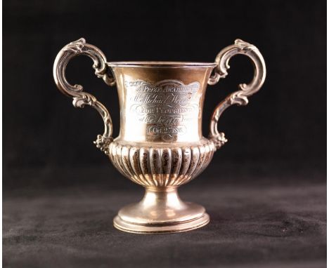 AN EARLY VICTORIAN SILVER TWO HANDLED TROPHY CUP, the campana shape demi-gadrooned body engraved with presentation inscriptio