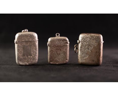 THREE VARIOUS VESTA BOXES, each oblong and hollowed and with vine leaf or flowerhead engraved decoration and ring suspension,
