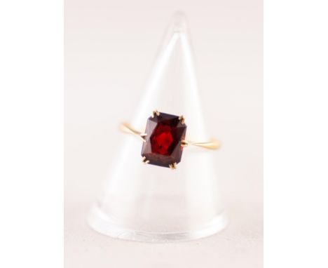 18ct GOLD DRESS RING WITH AN OBLONG GARNET in a six claw crown setting, 2.2gms, ring size 'M'