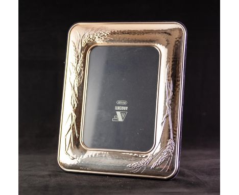 MODERN 925 MARK SILVER COLOURED METAL CLAD PHOTO FRAME of rounded oblong form and embossed with wheat ears on a planished gro