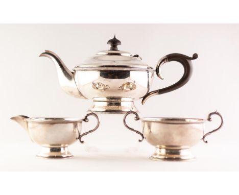 GEORGE V SILVER THREE PIECE TEA SET circular with circular foot and having beaded edges the teapot with ebony handle and fini