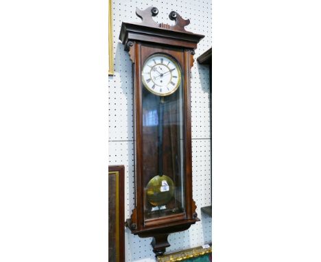 A Vienna style wall clock, the light enamelled two-part dial with Roman numerals, oak case and swan neck pediment, 112cm high