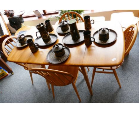 An Ercol elm and beech drop-leaf dining table, cat no.383, together with 4 Ercol Windsor chairs cat no.370 circa 1965, 135cm 
