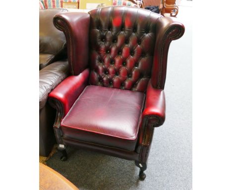 A winged button back leather armchair