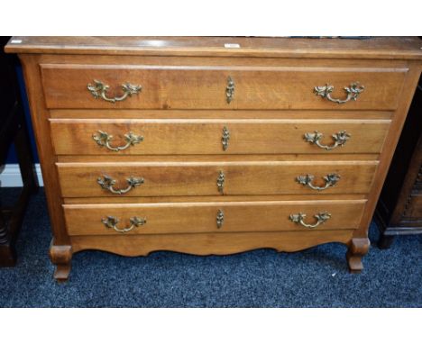 A Louis XV style oak commode, slightly oversailing rectangular top above four long drawers, brass Rococo type handles, shaped