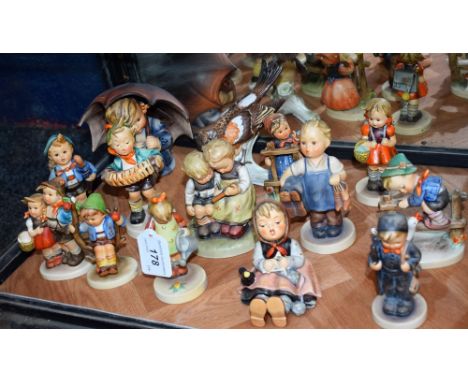 A collection of fourteen Goebel Hummel figures, including Girl Seated With Umbrella, ABC, Window Cleaner, Apple Tree Boy; etc
