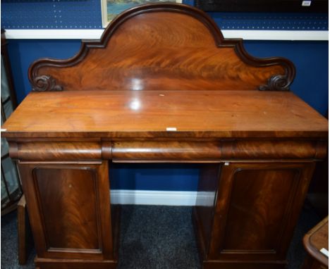 A Victorian mahogany twin pedestal sideboard, rectangular top with arched gallery terminating in carved scrolling acanthus, a