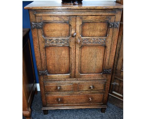 A 17th century style oak side cabinet, oversailing rectangular top above a pair of panel doors enclosing a shelf and two long